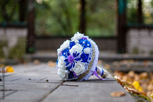 Wedding bouquet is lying on the ground on a blurry background. Wedding arrangement. Bridal bouquet. Focus on the bouquet. Wedding design concept. Wedding composition. White with blue.