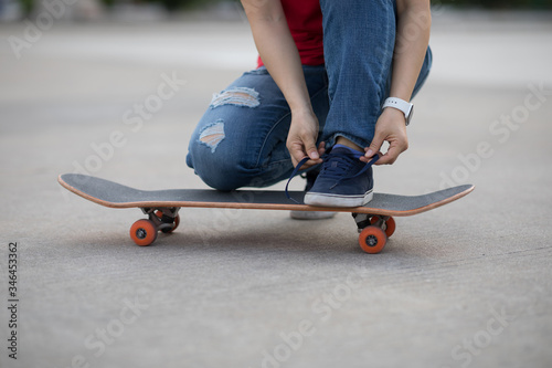 Skateboarder tying shoelace at outdoors
