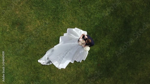 Aerial top view beautiful newlywed couple bride and groom outdoors. Wedding couple hugging. Happy Groom Kisses the Bride joy emotion love romantic