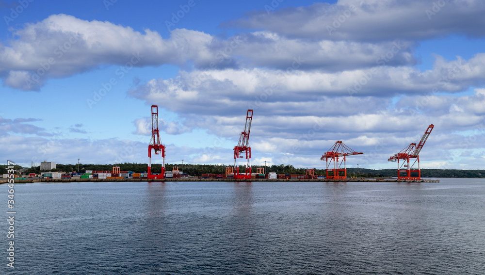 Fototapeta premium Heavy shipping cranes at a freight yard on the coast near Halifax, Nova Scotia, Canada