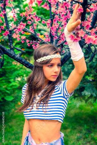 beautiful brunette girl in short striped blue and white shirt, swimsuit and pore on the street in the Park. Fashionable summer glamor concept. Summer walk. Retro style