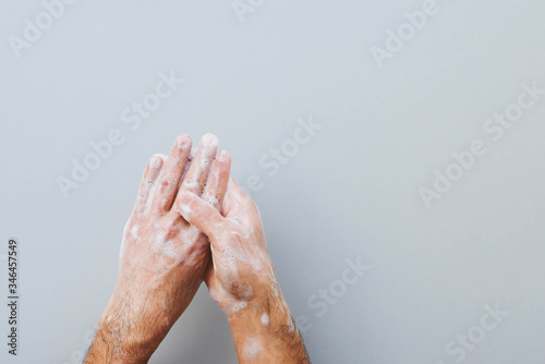 Man cleaning his hands using liquid disinfectant soap. photo