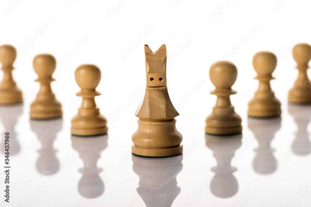 Selective focus of knight with pawns on white background Selective focus of knight with pawns on white background