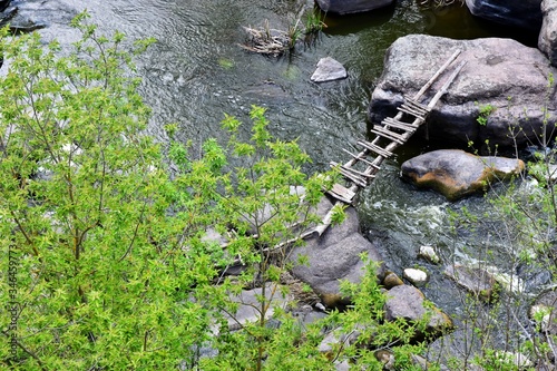 Wooden bridge over a mountain river Tikych in Buky canyon Cherkasy region, Ukraine. Granite canyon in Buki. Ukrainian landmarks. Domestic tourism. mountain river, extreme tourism. River rafting photo