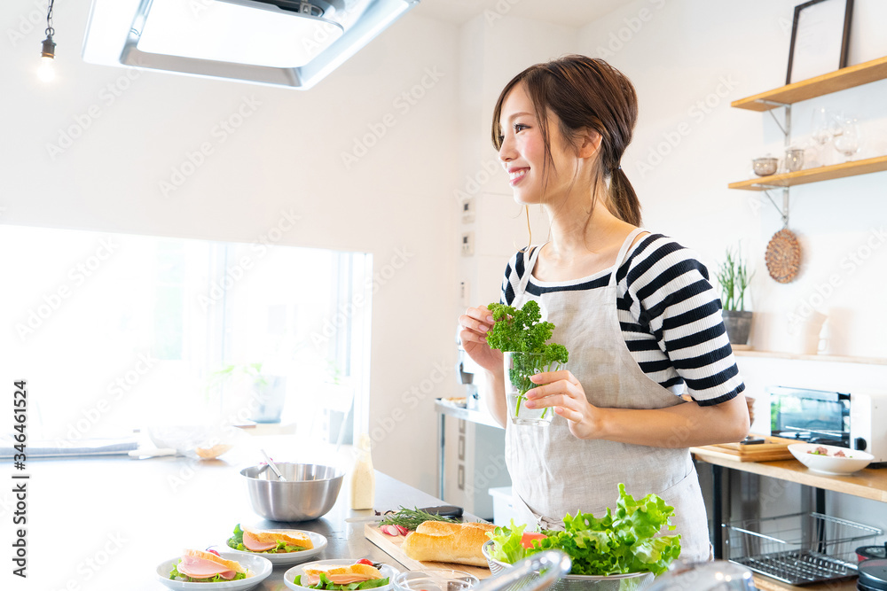 キッチンで料理を作る若い女性