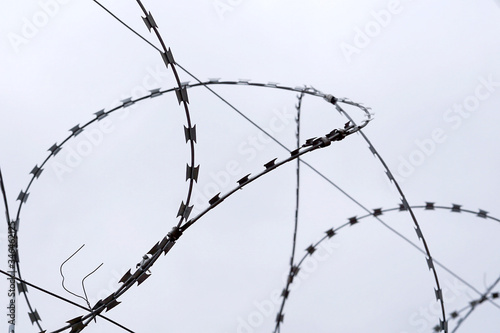 Barbed wire on gray sky background