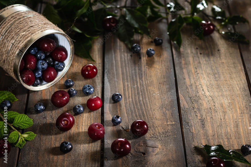 Berries in a can on a wooden background.