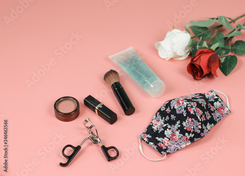  flower pattern fabric mask , woman's make up accessories,alcohol sanitizer hand gel ,red and white roses on pink background.protection from coronavirus of covid-19,new normal life style concept.