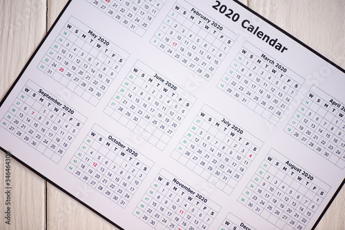 Top view of 2020 calendar on wooden background