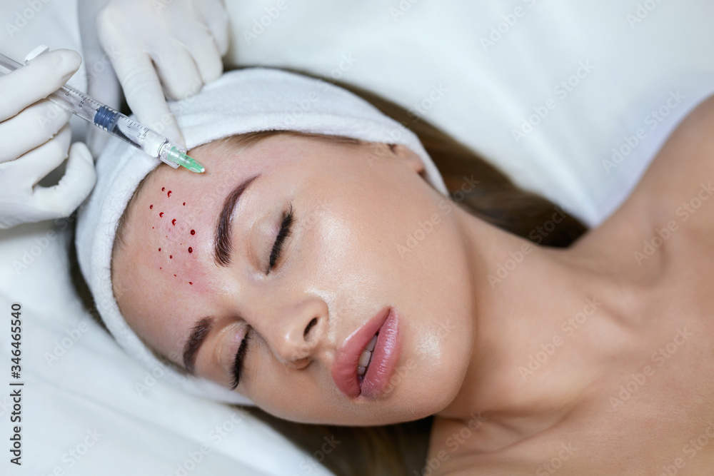 Face Beauty Treatment. Woman Receives Anti Aging Injection In Forehead. Cosmetology Skincare Thepary In Medical Clinic.