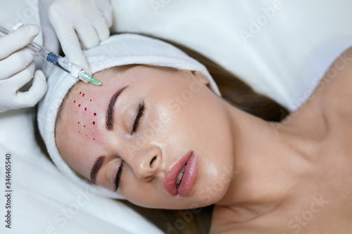 Face Beauty Treatment. Woman Receives Anti Aging Injection In Forehead. Cosmetology Skincare Thepary In Medical Clinic.