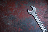 old wrench on old red rusty floor Top view with space for text. Plumber tools. Repair man equipment. Construction worker.