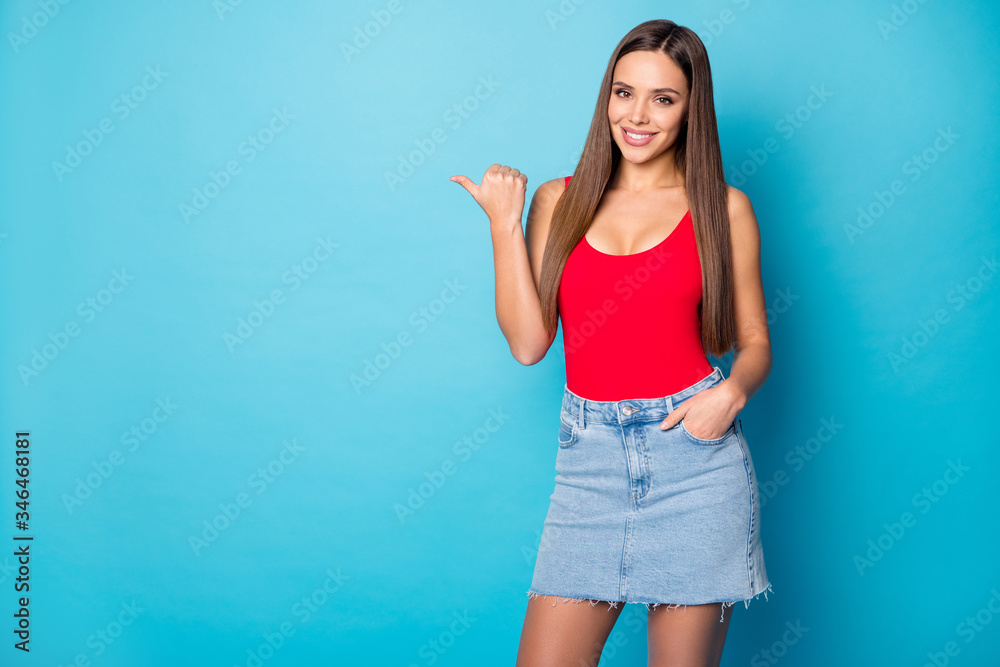 Portrait of positive cheerful girl promoter point forefinger copyspace demonstrate sales discount ads tips pick wear tank-top isolated over blue color background Portrait of positive cheerful girl promoter point forefinger copyspace demonstrate sales discount ads tips pick wear tank-top isolated over blue color background