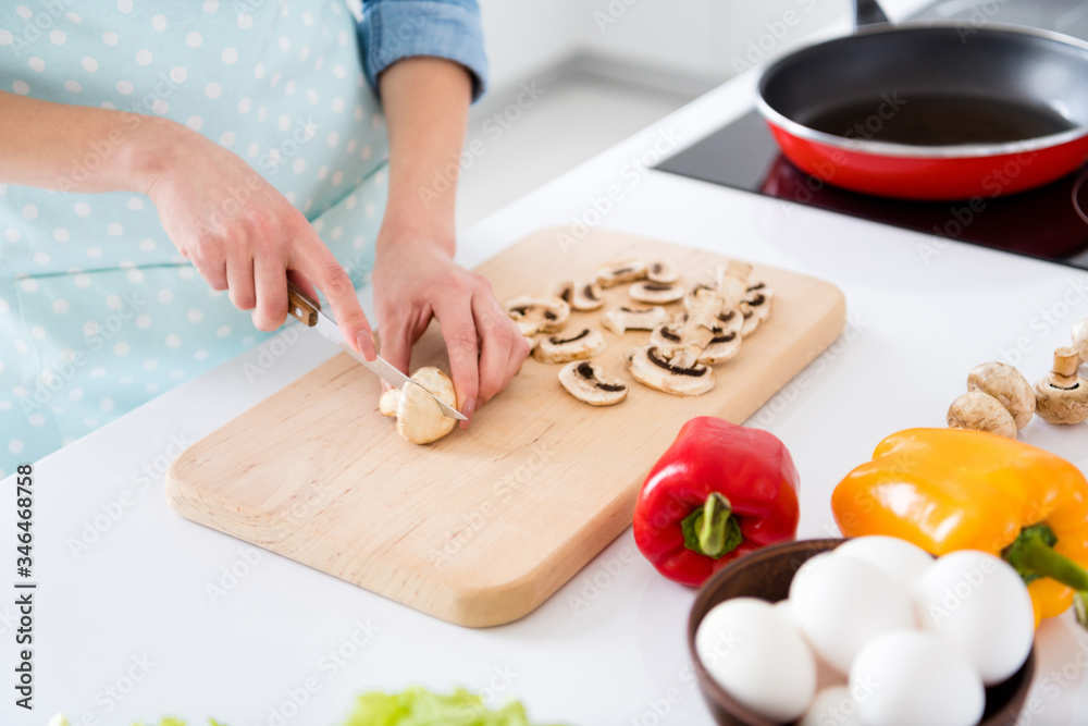 Cropped profile photo of housewife chef hold champignons cutting knife slices enjoy morning cooking tasty dinner family meeting wear apron shirt stand modern kitchen indoors