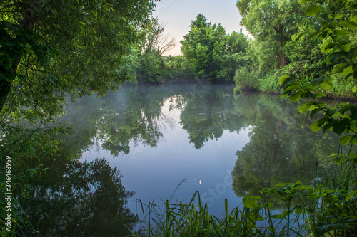 The river goes into the distance with lush dense vegetation on the banks. Background