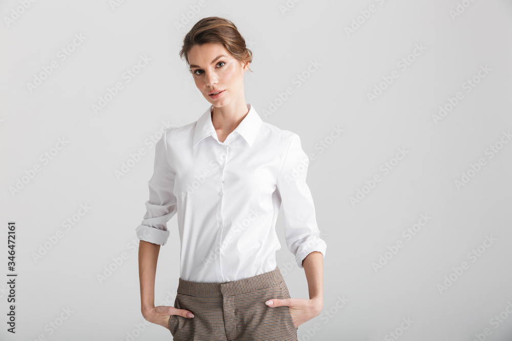 Image of young beautiful woman posing with hands in pockets Image of young beautiful woman posing with hands in pockets