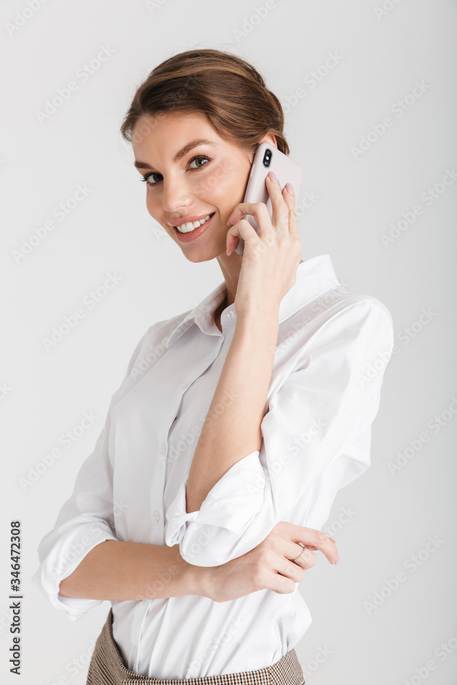 Image of pleased beautiful woman smiling and talking on mobile phone Image of pleased beautiful woman smiling and talking on mobile phone