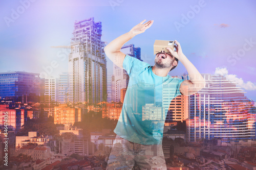 Double exposure of man using virtual reality headset and cityscape. Modern technology