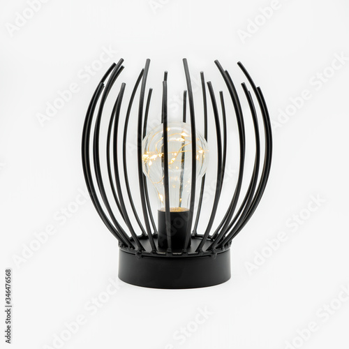 A table lamp with upright metal sticks and an LED light bulb inside, cut out on white background