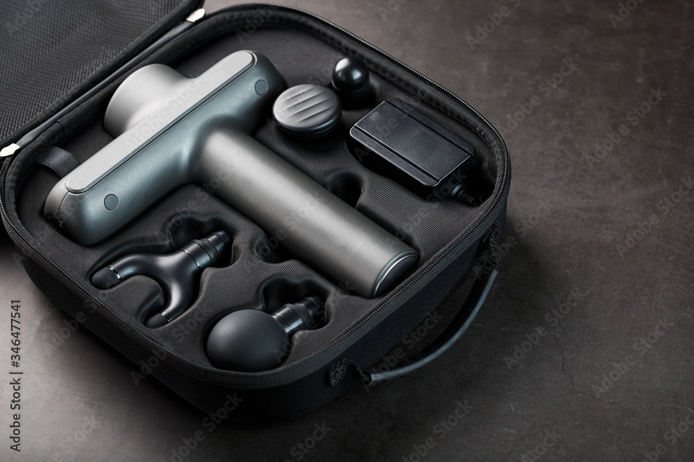 Electric massager Machine for body massage in a case on a black background. Electric massager Machine for body massage in a case on a black background.