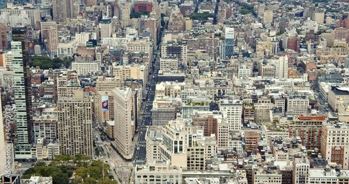 Famous Flatiron Building in New York City, amidst typical Manhattan buildings, parks, busy NY streets and skyscrapers.