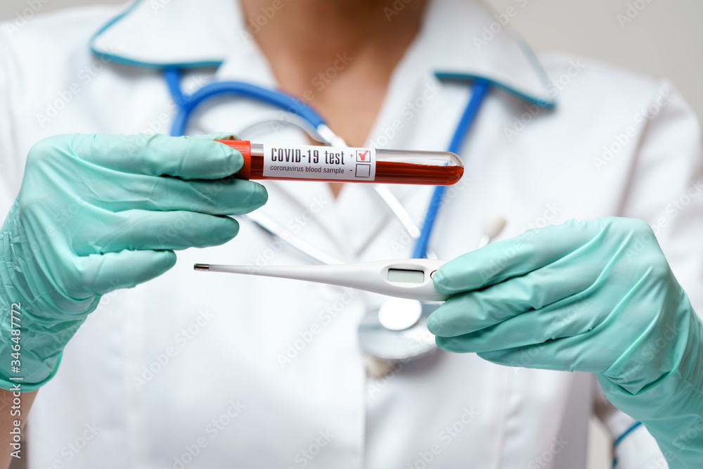 medical doctor nurse woman wearing protective mask and rubber or latex gloves - holding thermometer and virus blood test tube