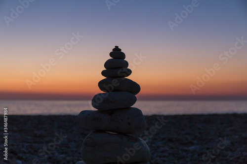 pyramid of stones on the background of sunset at sea