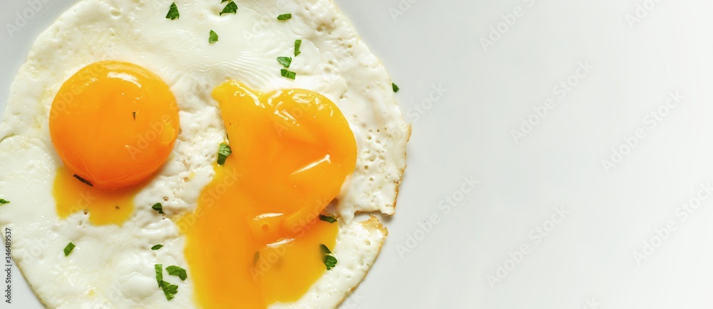 Fried eggs in a plate. Yolk close-up. Tasty breakfast. Appetizing egg breakfast. Isolated on white. Free space for text Fried eggs in a plate. Yolk close-up. Tasty breakfast. Appetizing egg breakfast. Isolated on white. Free space for text
