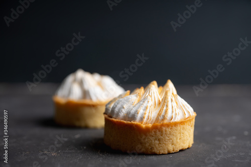 Creamy cake decorated with meringue cream on the rustic background. Selective focus. Shallow depth of field.
