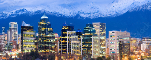 Skyline of modern office buildings at Las Condes and Providencia districts with snowed Andes mountain Range in the back, Santiago de Chile, South America photo