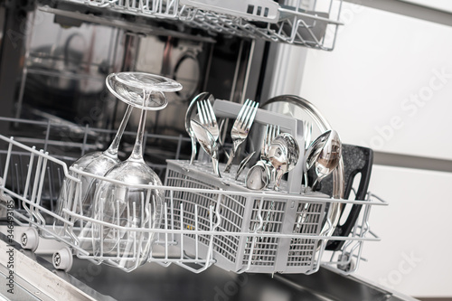 Open dishwasher with clean utensils in it