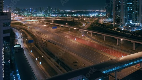 Aerial night view of empty highway and interchange in Dubai after epidemic lockdown. Cityscapes with disappearing traffic on streets. Roads and lanes crossroads without cars, Dubai marina and JLT photo