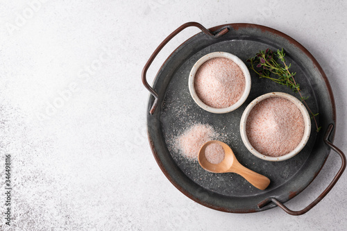 pink Himalayan salt in a bowl on a light background. Top view, place for text