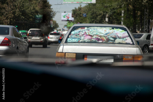 Full car of fabric things. Traffic in the city.