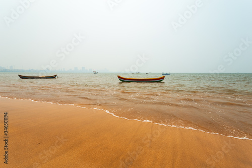 Beautiful Arabian sea, girgaon chowpatty beach.  Empty fishing boats on water. Bright sunny afternoon.  © Pritha_EasyArts