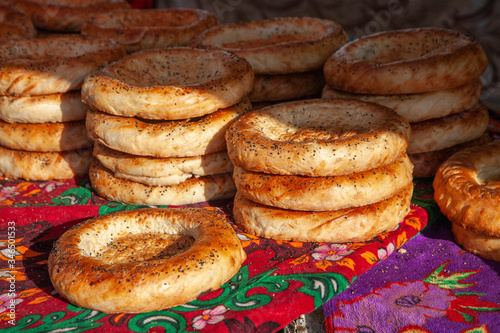 Close-up of fresh bread with poppy seeds from tandoor. Food market in Central Asia. Tasty food.