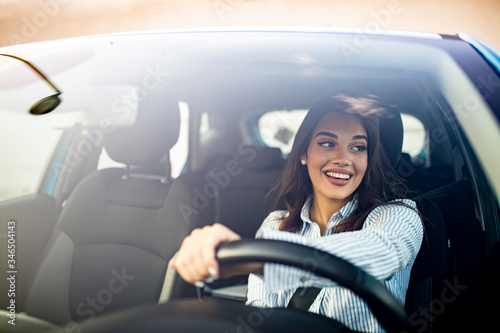 Canvastavla Happy woman driving a car and smiling