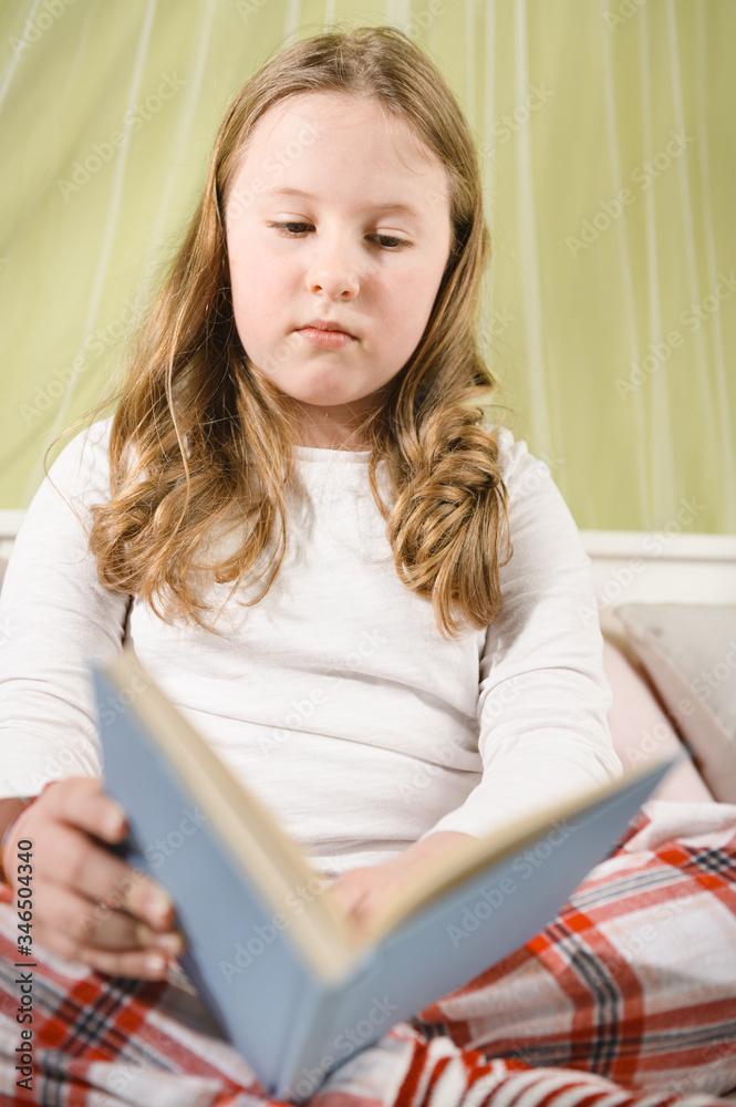Beautiful blond girl sick in bed reading a book Beautiful blond girl sick in bed reading a book