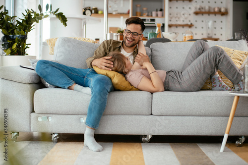 Young loving couple in sofa. Happy couple relaxing in living room.