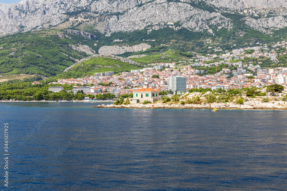 Makarska in Dalmatia, Croatia. View from the sea on a sunny day in the summer. A famous place with beaches and the Biokovo mountain. Holiday destination at the Mediterranean coast. Relaxing