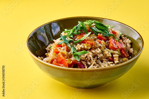 Bowl with Fried Rice and Vegetables. Traditional chinese food. horizontal view on yellow