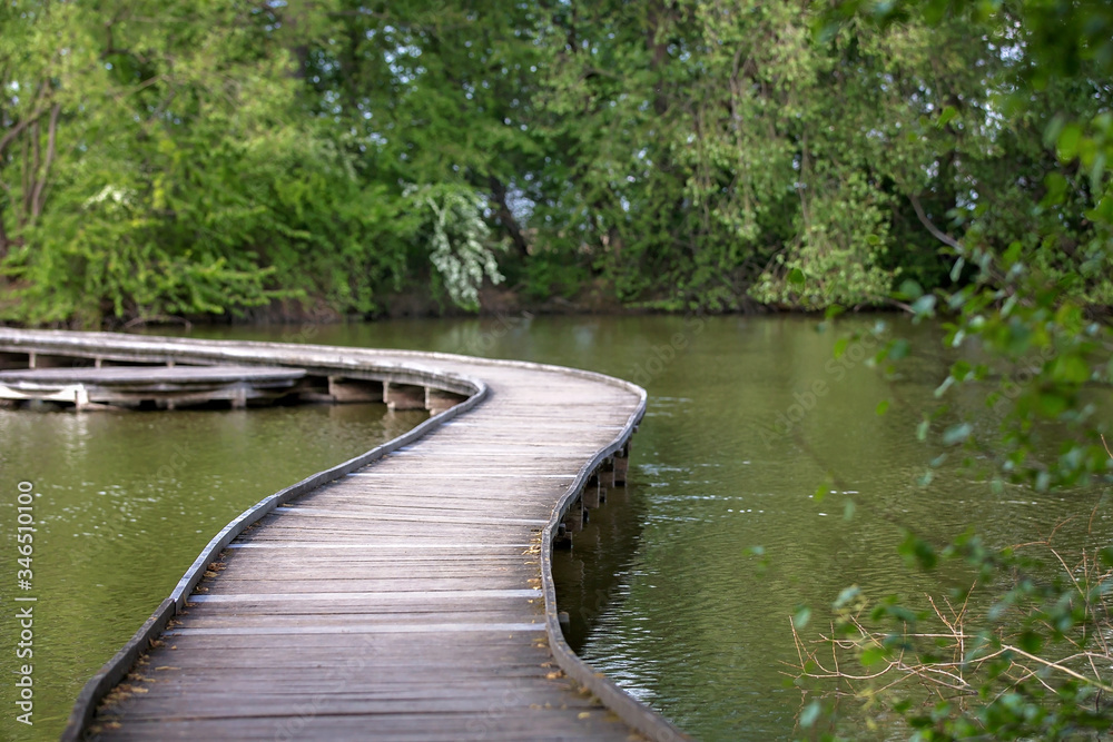 Child, boy, sitting or running on a wooden bridge over lake Child, boy, sitting or running on a wooden bridge over lake