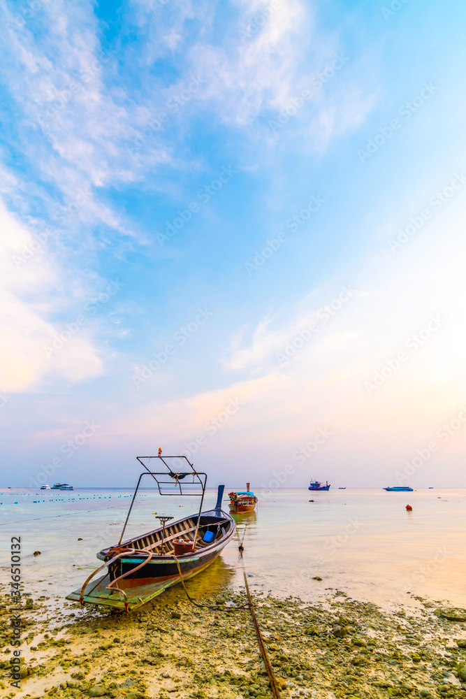 Magic sunset above small harbor with long tail boats at Ko Lipe island, Thailand. Tropical island is part of Tarutao national nature park. Soft light, concept of romantic evening in tropical paradise. Magic sunset above small harbor with long tail boats at Ko Lipe island, Thailand. Tropical island is part of Tarutao national nature park. Soft light, concept of romantic evening in tropical paradise.