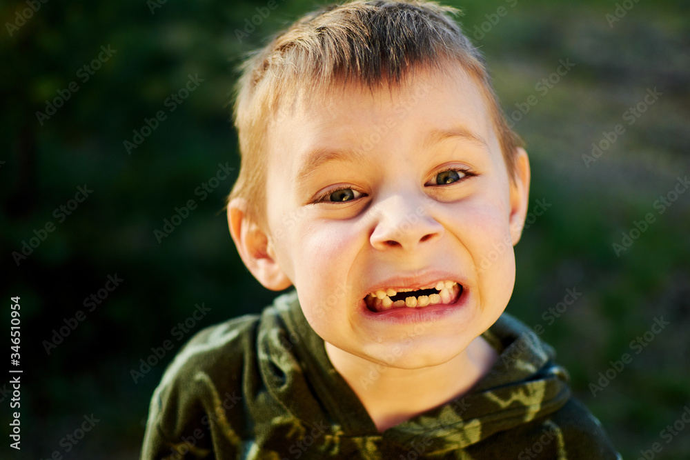The boy smiles in the park. The boy smiles in the park.