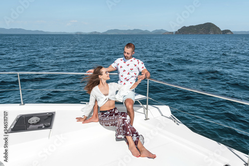 Young couple relaxing at the edge of yacht by sea.  Summer cruise. Trip to warm destination © Detkov D