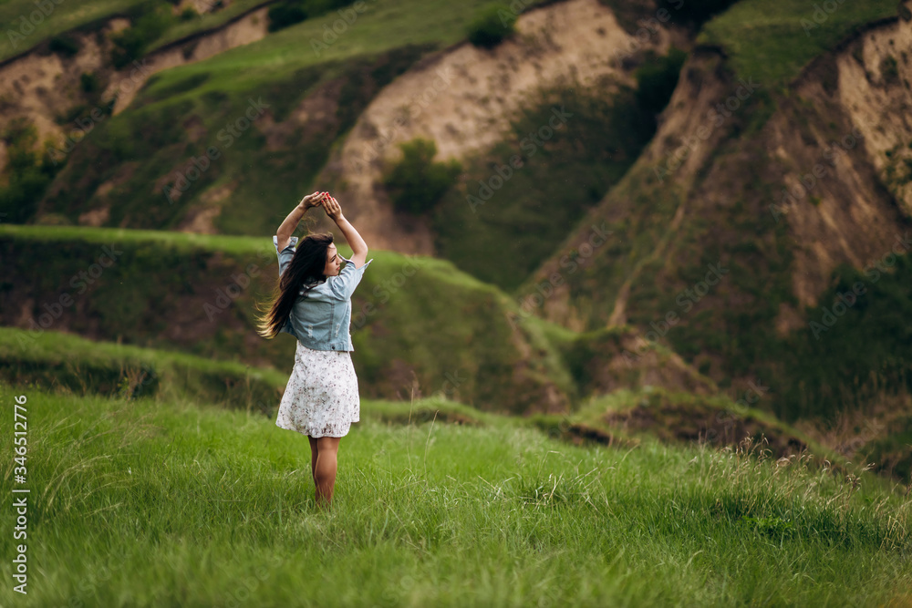 young beautiful girl runs on the green hills of the mountains young beautiful girl runs on the green hills of the mountains