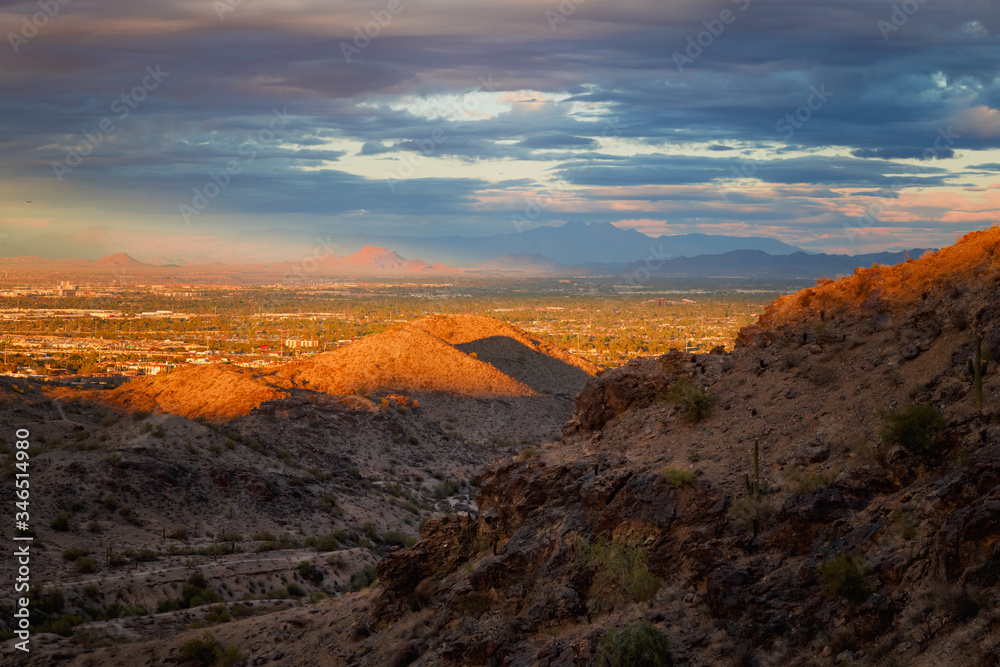 A landscape with dramatic sun light on the mountains. A beautiful view of the valley, red mountain and four peaks at the backdrop can be seen from south mountain, Phoenix Arizona. Selective focus.