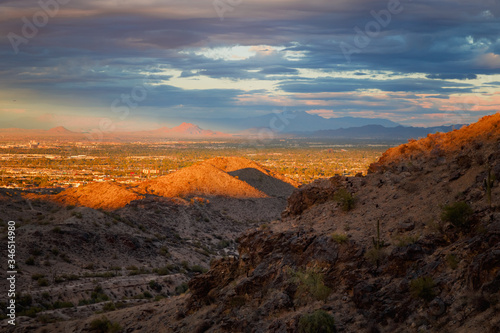 A landscape with dramatic sun light on the mountains. A beautiful view of the valley, red mountain and four peaks at the backdrop can be seen from south mountain, Phoenix Arizona. Selective focus.