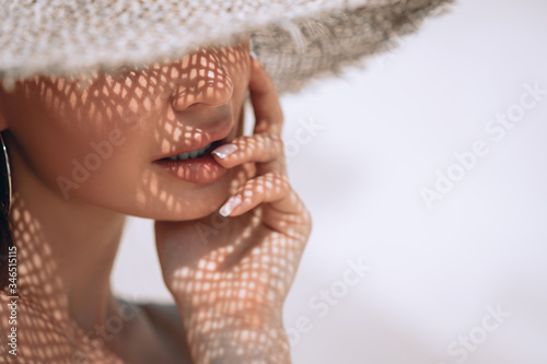Portrait of a beautiful woman in a straw hat with french manicure. Cosmetics,makeup and beauty. Spa. Copy space