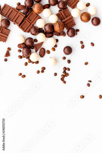 Chocolate background on white table top-down frame. Sweet desserts concept. Copy space